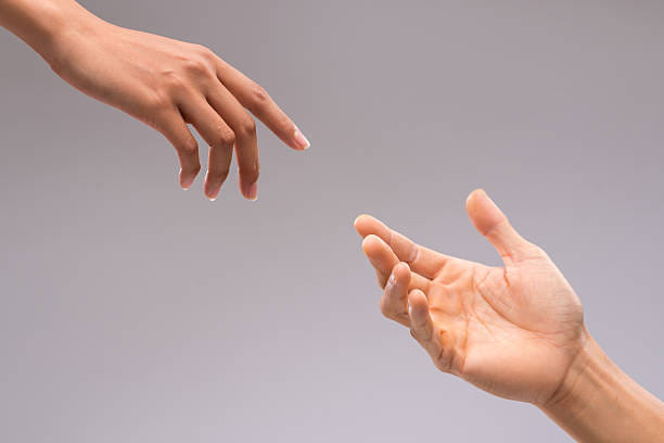 Hands of man and woman reaching to each other